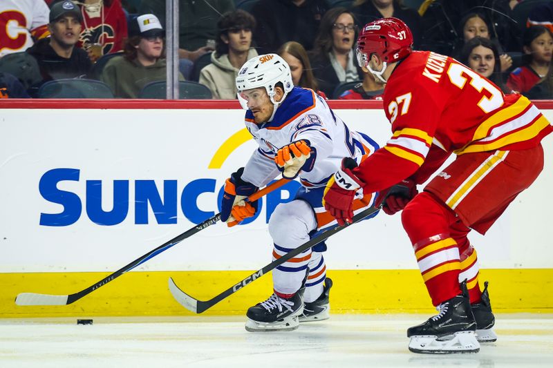 Dec 27, 2025; Calgary, Alberta, CAN; Edmonton Oilers center Jack Roslovic (28) and Calgary Flames defenseman Yan Kuznetsov (37) battle for the puck during the first period at Scotiabank Saddledome. Mandatory Credit: Sergei Belski-Imagn Images