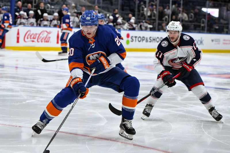 Dec 7, 2023; Elmont, New York, USA; New York Islanders right wing Hudson Fasching (20) skates with the puck against Columbus Blue Jackets right wing Justin Danforth (17) during the second period at UBS Arena. Mandatory Credit: John Jones-USA TODAY Sports