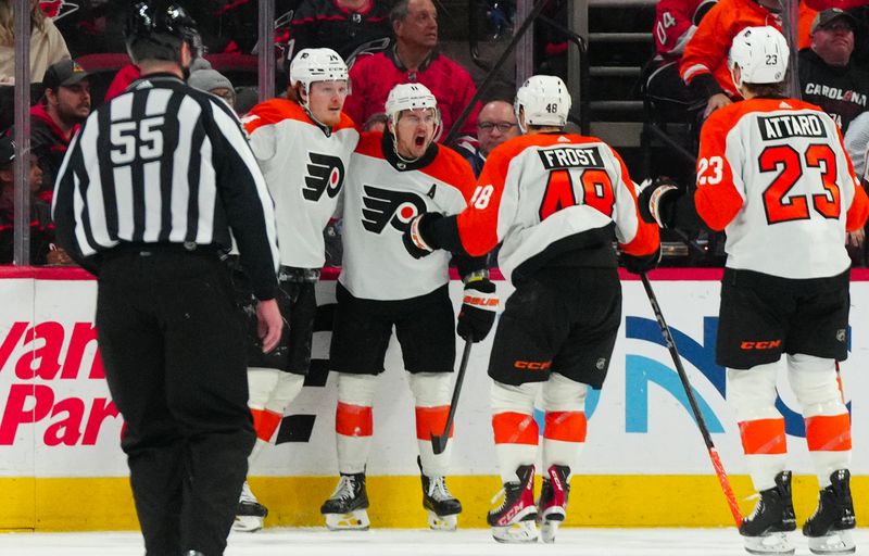 Mar 21, 2024; Raleigh, North Carolina, USA; Philadelphia Flyers right wing Travis Konecny (11) is congratulated by right wing Owen Tippett (74) and  center Morgan Frost (48) after his goal against the Carolina Hurricanes during the third period at PNC Arena. Mandatory Credit: James Guillory-USA TODAY Sports