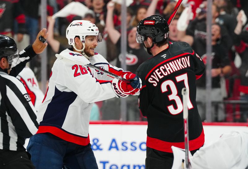 May 10, 2025; Raleigh, North Carolina, USA; Carolina Hurricanes right wing Andrei Svechnikov (37) and Washington Capitals center Nic Dowd (26) battle during the third period in game three of the second round of the 2025 Stanley Cup Playoffs at Lenovo Center. Mandatory Credit: James Guillory-Imagn Images