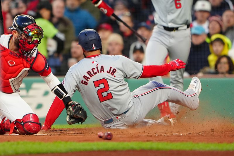 May 10, 2024; Boston, Massachusetts, USA; Washington Nationals second baseman Luis Garcia Jr. (2) scores a run ahead of the tag by Boston Red Sox catcher Connor Wong (12) on Washington Nationals first baseman Joey Meneses (not pictured) RBI single during the third inning at Fenway Park. Mandatory Credit: Gregory Fisher-USA TODAY Sports