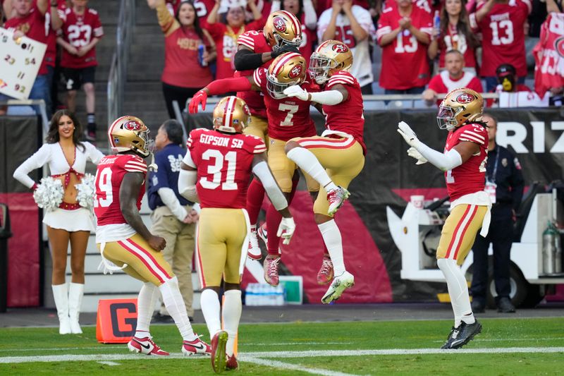 San Francisco 49ers cornerback Charvarius Ward (7) is congratulated by teammates after returning an interception for a touchdown during the first half of an NFL football game against the Arizona Cardinals Sunday, Dec. 17, 2023, in Glendale, Ariz. (AP Photo/Ross D. Franklin)