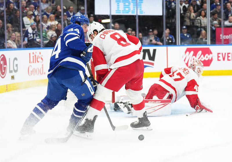 Apr 13, 2024; Toronto, Ontario, CAN; Toronto Maple Leafs center Auston Matthews (34) battles for the puck with Detroit Red Wings defenseman Ben Chiarot (8) during the first period at Scotiabank Arena. Mandatory Credit: Nick Turchiaro-USA TODAY Sports