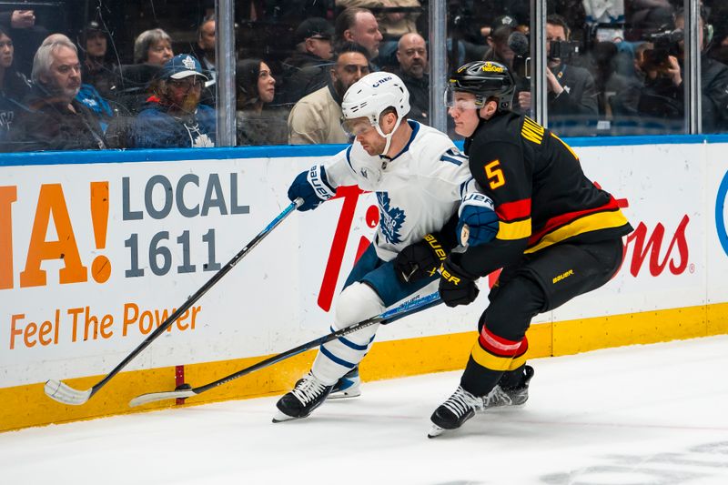 Jan 31, 2026; Vancouver, British Columbia, CAN; Vancouver Canucks defenseman Tom Willander (5) checks Toronto Maple Leafs forward Max Domi (11) in the first period at Rogers Arena. Mandatory Credit: Bob Frid-Imagn Images