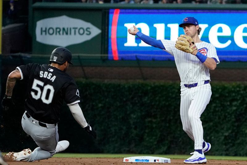 Jun 4, 2024; Chicago, Illinois, USA; Chicago Cubs second base Nico Hoerner (2) forces out Chicago White Sox third baseman Lenyn Sosa (50) at second base then throws to first base to complete a double play during the second inningat Wrigley Field. Mandatory Credit: David Banks-USA TODAY Sports