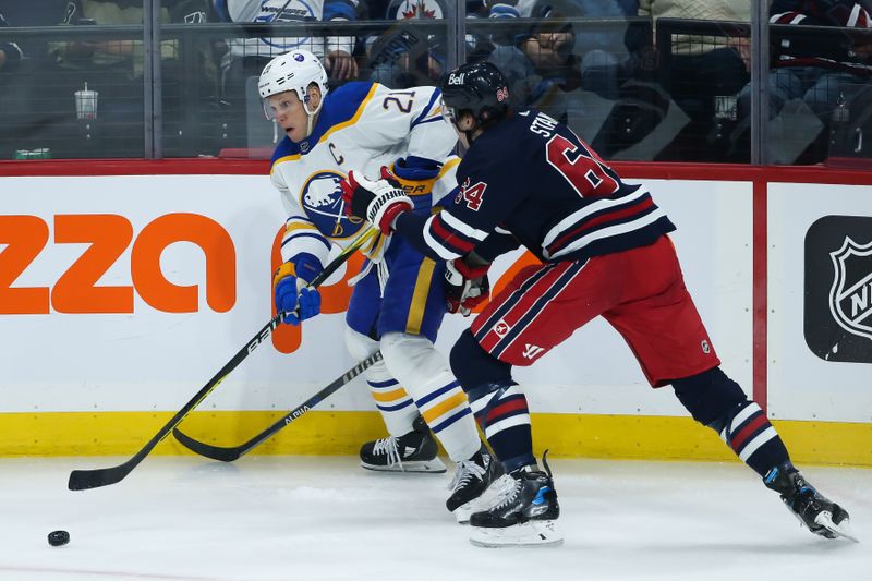 Jan 26, 2023; Winnipeg, Manitoba, CAN;  Buffalo Sabres forward Kyle Okposo (21) skates away from Winnipeg Jets defenseman Logan Stanley (64) during the third period at Canada Life Centre. Mandatory Credit: Terrence Lee-USA TODAY Sports