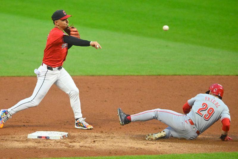 Sep 24, 2024; Cleveland, Ohio, USA; Cleveland Guardians second baseman Andres Gimenez (0) turns a double play beside Cincinnati Reds center fielder TJ Friedl (29) in the second inning at Progressive Field. Mandatory Credit: David Richard-Imagn Images