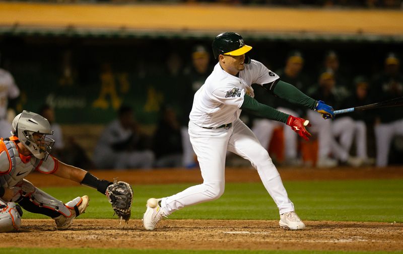 Aug 19, 2023; Oakland, California, USA; Oakland Athletics left fielder Aledmys D  az (12) swings and misses at strike three during the 10th inning at Oakland-Alameda County Coliseum. Mandatory Credit: D. Ross Cameron-USA TODAY Sports