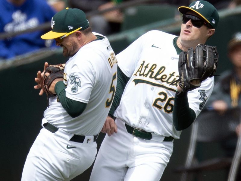 Apr 3, 2024; Oakland, California, USA; Oakland Athletics left fielder Tyler Nevin (26) nearly collides with third baseman J.D. Davis (5) as they both pursue a popup by Boston Red Sox right fielder Wilyer Abreu during the fifth inning at Oakland-Alameda County Coliseum. Mandatory Credit: D. Ross Cameron-USA TODAY Sports