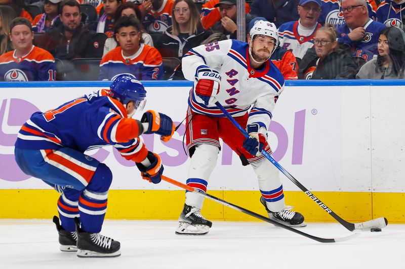 Nov 23, 2024; Edmonton, Alberta, CAN; New York Rangers defensemen Ryan Lindgren (55) makes a pass in front of Edmonton Oilers defensemen Troy Stecher (51) during the second period at Rogers Place. Mandatory Credit: Perry Nelson-Imagn Images