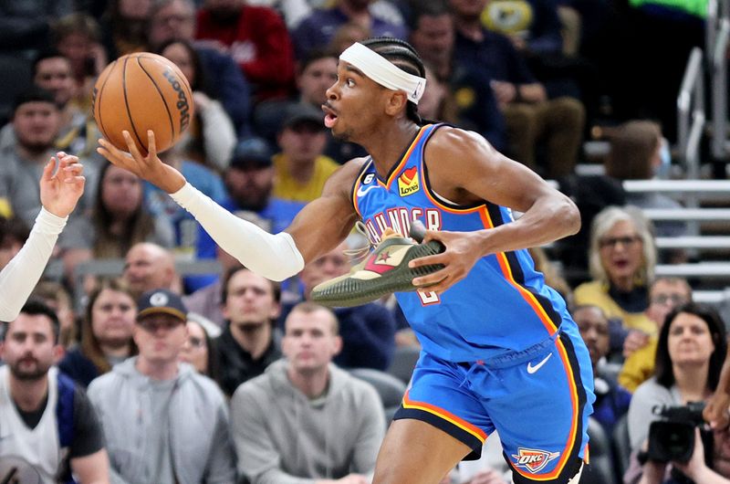 INDIANAPOLIS, INDIANA - MARCH 31:  Shai Gilgeous-Alexander #2 of the Oklahoma City Thunder reaches for a rebound while holding his shoe against Indiana Pacers at Gainbridge Fieldhouse on March 31, 2023 in Indianapolis, Indiana.    NOTE TO USER: User expressly acknowledges and agrees that, by downloading and/or using this photograph, User is consenting to the terms and conditions of the Getty Images License Agreement. (Photo by Andy Lyons/Getty Images)