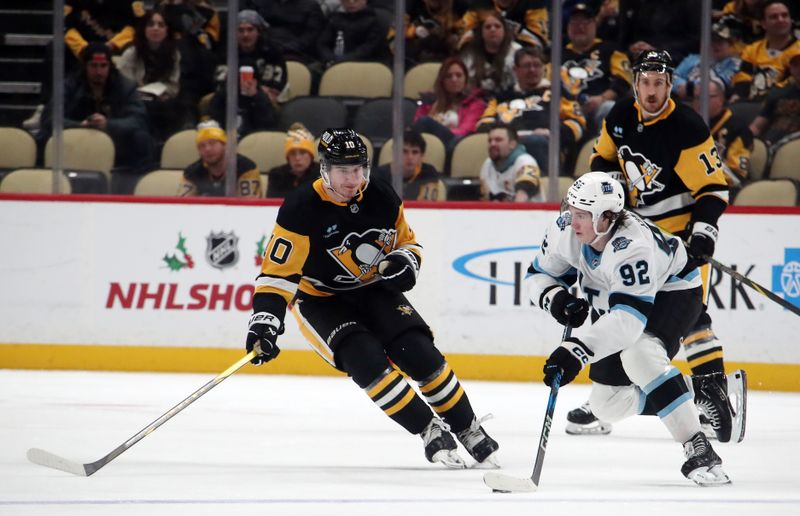 Nov 23, 2024; Pittsburgh, Pennsylvania, USA;  Utah Hockey Club center Logan Cooley (92) moves the puck against Pittsburgh Penguins left wing Drew O'Connor (10) during the third period at PPG Paints Arena. Mandatory Credit: Charles LeClaire-Imagn Images