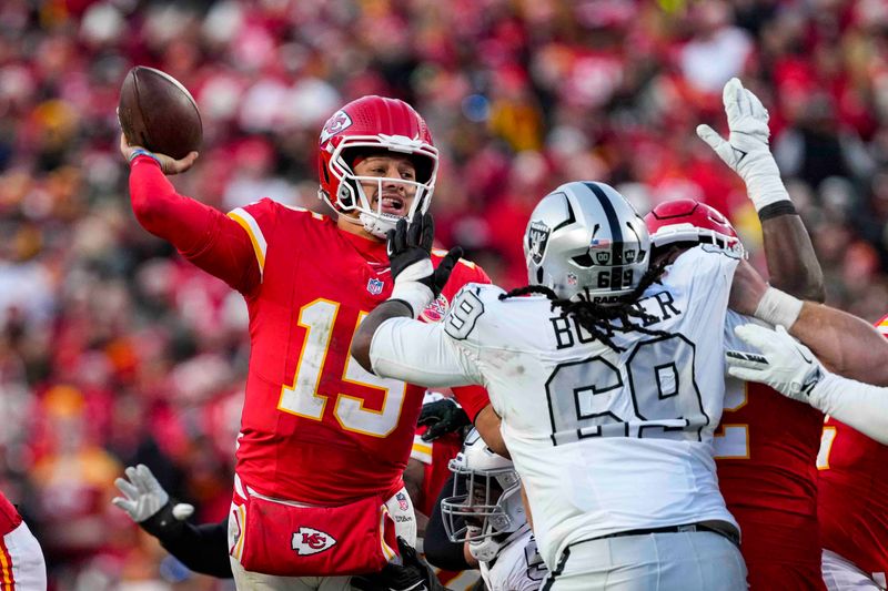 Kansas City Chiefs quarterback Patrick Mahomes (15) throws over Las Vegas Raiders defensive tackle Adam Butler (69) during the second half of an NFL football game in Kansas City, Mo., Friday, Nov. 29, 2024. (AP Photo/Ed Zurga)