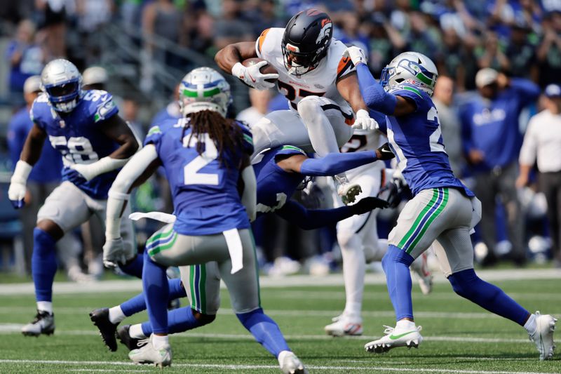 Denver Broncos running back Audric Estime (23) leaps over Seattle Seahawks safety Julian Love (20) during the first half of an NFL football game Sunday, Sept. 8, 2024, in Seattle. (AP Photo/John Froschauer)