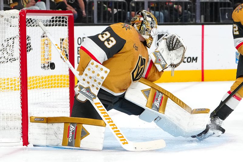 Nov 2, 2024; Las Vegas, Nevada, USA; A shot by Utah Hockey Club center Logan Cooley (92) scores behind Vegas Golden Knights goaltender Adin Hill (33) during the first period at T-Mobile Arena. Mandatory Credit: Stephen R. Sylvanie-Imagn Images