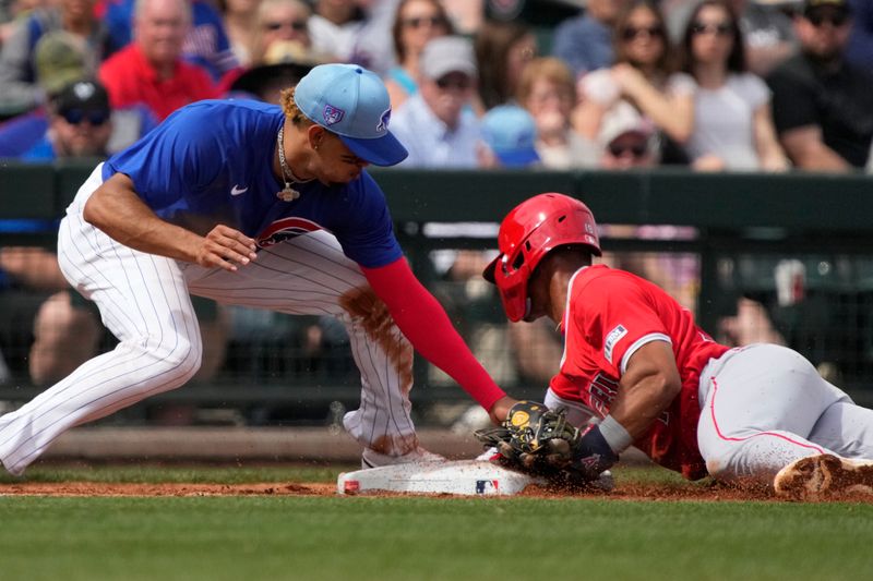 Mar 6, 2024; Mesa, Arizona, USA; Chicago Cubs third baseman Christopher Morel (5) tries tagging oput Los Angeles Angels second baseman Kyren Paris (19) in the third inning at Sloan Park. Mandatory Credit: Rick Scuteri-USA TODAY Sports