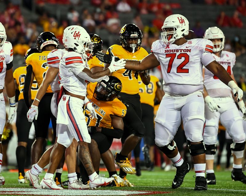 Sep 18, 2021; Houston, Texas, USA;  Houston Cougars running back Ta'Zhawn Henry (4) celebrates with offensive lineman Tank Jenkins (72) after scoring a touchdown against the Grambling State Tigers in the fourth quarter at TDECU Stadium. Mandatory Credit: Maria Lysaker-USA TODAY Sports