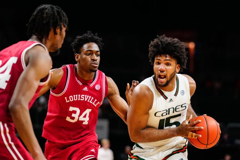 Feb 11, 2023; Coral Gables, Florida, USA; Miami (Fl) Hurricanes forward Norchad Omier (15) dribbles the ball past Louisville Cardinals forward Emmanuel Okorafor (34) during the second half at Watsco Center. Mandatory Credit: Rich Storry-USA TODAY Sports