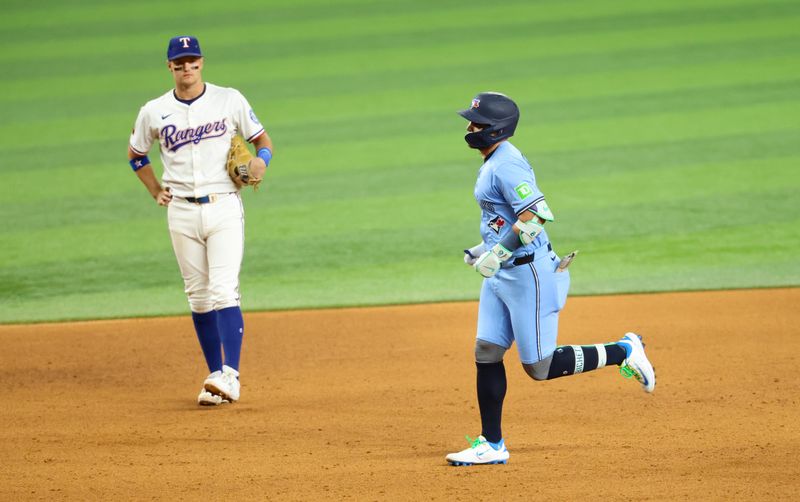 May 28, 2025; Arlington, Texas, USA; Toronto Blue Jays shortstop Bo Bichette (11) runs the bases past Texas Rangers shortstop Josh Smith (8) after hitting a two-run home run during the ninth inning at Globe Life Field. Mandatory Credit: Kevin Jairaj-Imagn Images