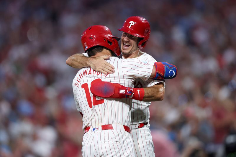 Aug 14, 2024; Philadelphia, Pennsylvania, USA; Philadelphia Phillies designated hitter Kyle Schwarber (12) celebrates with catcher J.T. Realmuto (10) after hitting a four RBI grand slam during the fourth inning against the Miami Marlins at Citizens Bank Park. Mandatory Credit: Bill Streicher-USA TODAY Sports