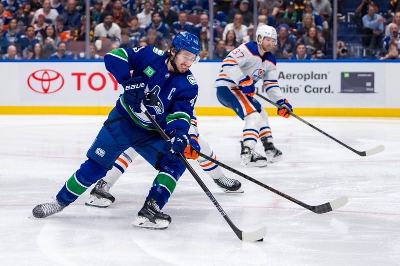 May 10, 2024; Vancouver, British Columbia, CAN; Vancouver Canucks defenseman Quinn Hughes (43) shoots against the Edmonton Oilers during the third period in game two of the second round of the 2024 Stanley Cup Playoffs at Rogers Arena. Mandatory Credit: Bob Frid-USA TODAY Sports