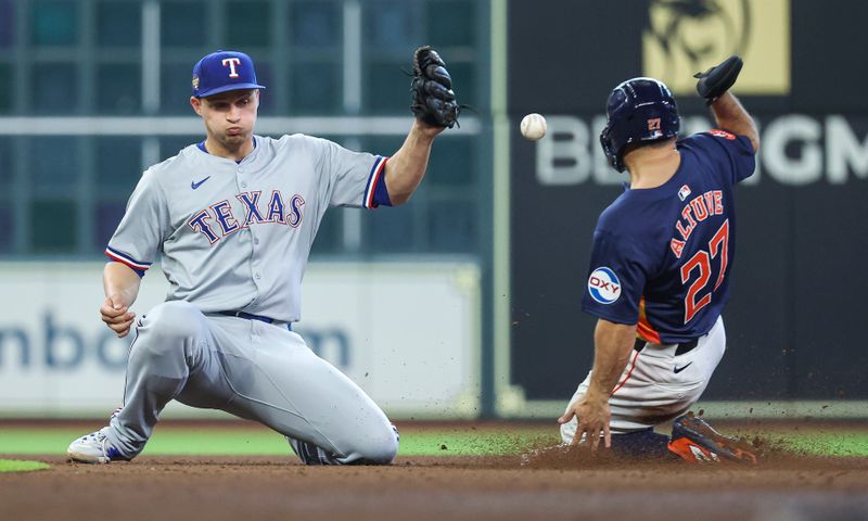 Apr 14, 2024; Houston, Texas, USA; Houston Astros second baseman Jose Altuve (27) is safe at second base with a stolen base as Texas Rangers shortstop Corey Seager (5) is unable to field the throw during the seventh inning at Minute Maid Park. Mandatory Credit: Troy Taormina-USA TODAY Sports