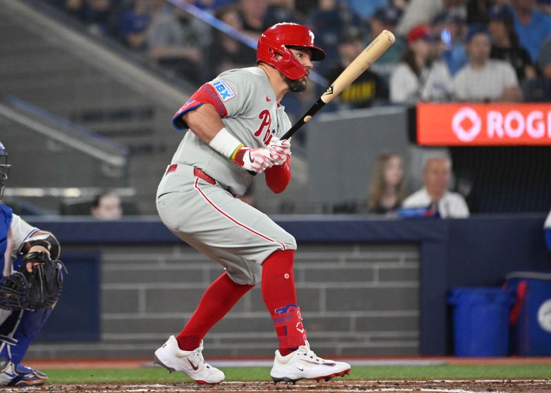Jun 4, 2025; Toronto, Ontario, CAN;  Philadelphia Phillies designated hitter Kyle Schwarber (12) hits a single against the Toronto Blue Jays in the fourth inning at Rogers Centre. Mandatory Credit: Dan Hamilton-Imagn Images
