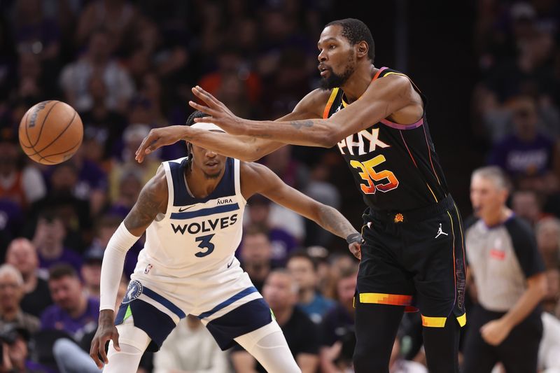 PHOENIX, ARIZONA - APRIL 28: Kevin Durant #35 of the Phoenix Suns passes the ball against Jaden McDaniels #3 of the Minnesota Timberwolves during the first half of game four of the Western Conference First Round Playoffs at Footprint Center on April 28, 2024 in Phoenix, Arizona. NOTE TO USER: User expressly acknowledges and agrees that, by downloading and or using this photograph, User is consenting to the terms and conditions of the Getty Images License Agreement.  (Photo by Christian Petersen/Getty Images)