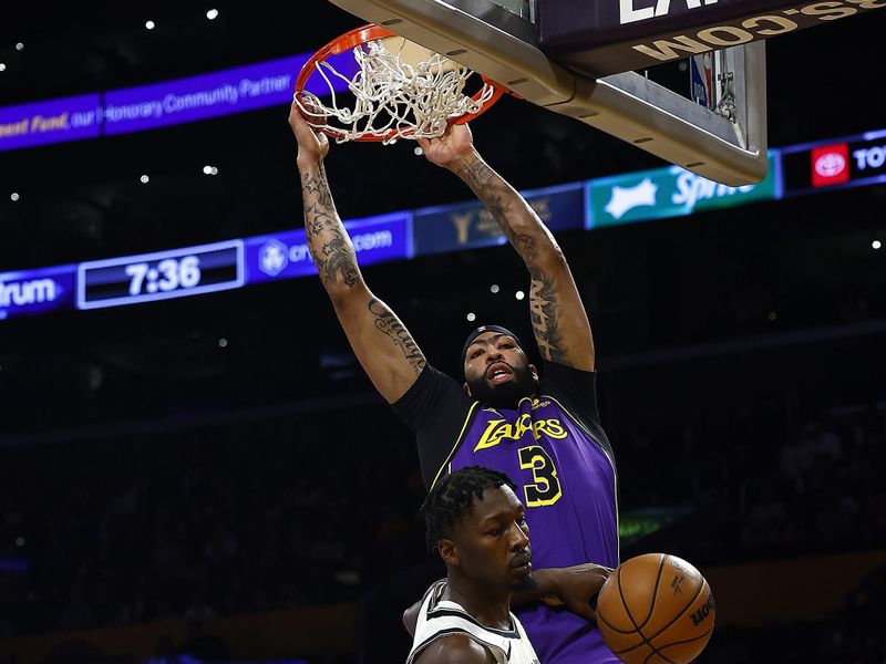 LOS ANGELES, CALIFORNIA - JANUARY 19:  Anthony Davis #3 of the Los Angeles Lakers makes the slam dunk against Nic Claxton #33 of the Brooklyn Nets in the first half at Crypto.com Arena on January 19, 2024 in Los Angeles, California.  NOTE TO USER: User expressly acknowledges and agrees that, by downloading and/or using this photograph, user is consenting to the terms and conditions of the Getty Images License Agreement.  (Photo by Ronald Martinez/Getty Images)