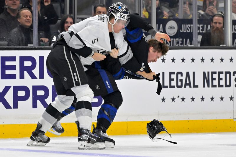 Jan 2, 2024; Los Angeles, California, USA; Los Angeles Kings defenseman Andreas Englund (5) and Toronto Maple Leafs defenseman Simon Benoit (2) fight during the third period at Crypto.com Arena. Mandatory Credit: Jayne Kamin-Oncea-USA TODAY Sports