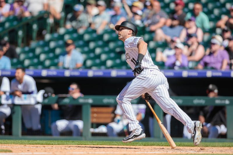 Jun 5, 2024; Denver, Colorado, USA; Colorado Rockies outfielder Jake Cave (11) hits an RBI double during the eighth inning against the Cincinnati Reds at Coors Field. Mandatory Credit: Andrew Wevers-USA TODAY Sports