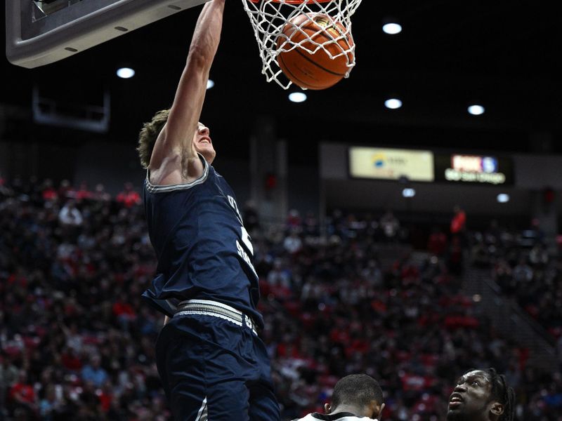 Jan 25, 2023; San Diego, California, USA; Utah State Aggies guard Sean Bairstow (2) dunks the ball over San Diego State Aztecs guard Lamont Butler (5) during the second half at Viejas Arena. Mandatory Credit: Orlando Ramirez-USA TODAY Sports