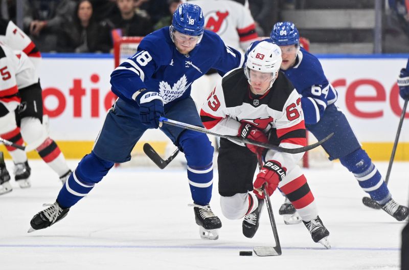 Jan 16, 2025; Toronto, Ontario, CAN; New Jersey Devils forward Jesper Bratt (63) skates with the puck past Toronto Maple Leafs forward Steven Lorentz (18) in the second period at Scotiabank Arena. Mandatory Credit: Dan Hamilton-Imagn Images