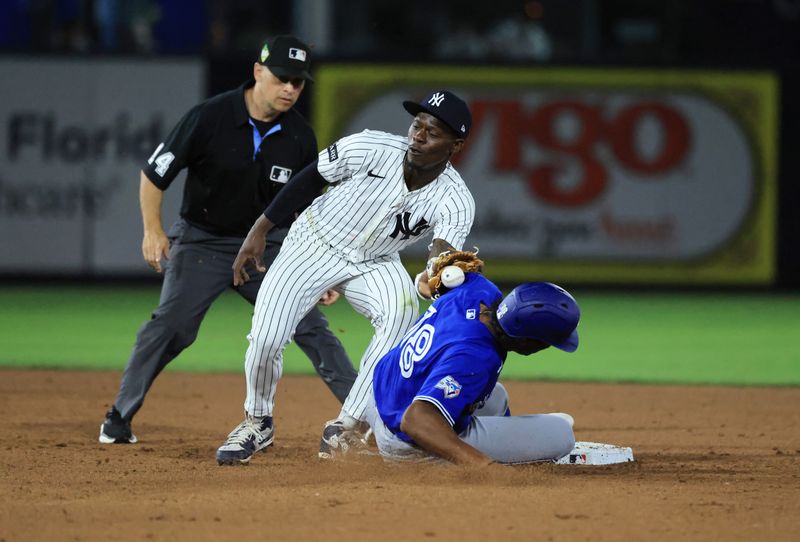 Mar 11, 2026; Tampa, Florida, USA;  Toronto Blue Jays infielder Arjun Nimmala (18) slides safe into second base as New York Yankees second baseman Jazz Chisholm Jr. (13) attempted to tag him out during the fifth inning at George M. Steinbrenner Field. Mandatory Credit: Kim Klement Neitzel-Imagn Images