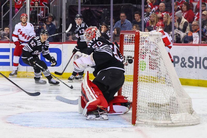 Mar 9, 2024; Newark, New Jersey, USA; Carolina Hurricanes center Jesperi Kotkaniemi (82) scores a goal on New Jersey Devils goaltender Nico Daws (50) during the third period at Prudential Center. Mandatory Credit: Ed Mulholland-USA TODAY Sports