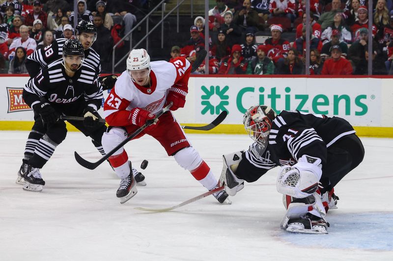 Dec 23, 2023; Newark, New Jersey, USA; New Jersey Devils goaltender Vitek Vanecek (41) pokes the puck away from Detroit Red Wings left wing Lucas Raymond (23) during the first period at Prudential Center. Mandatory Credit: Ed Mulholland-USA TODAY Sports