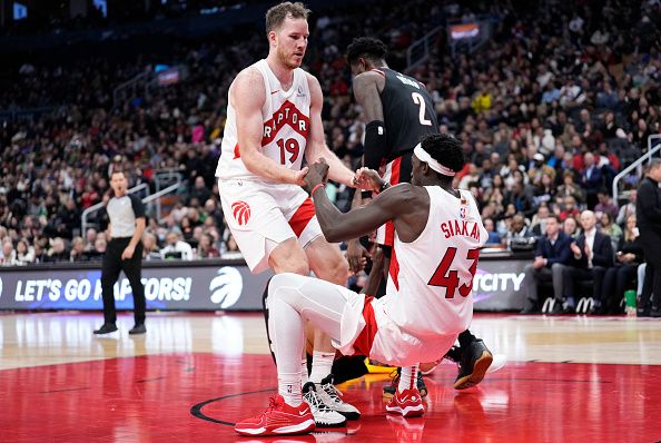 TORONTO, ON - OCTOBER 30: Jakob Poeltl #19 of the Toronto Raptors picks up teammate Pascal Siakam #43 against the Portland Trail Blazers during the second half of their basketball game at the Scotiabank Arena on October 30, 2023 in Toronto, Ontario, Canada. NOTE TO USER: User expressly acknowledges and agrees that, by downloading and/or using this Photograph, user is consenting to the terms and conditions of the Getty Images License Agreement. (Photo by Mark Blinch/Getty Images)