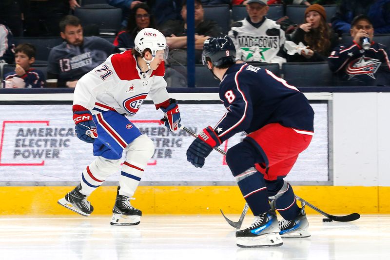 Nov 27, 2024; Columbus, Ohio, USA; Montreal Canadiens center Jake Evans (71) skates with the puck as Columbus Blue Jackets defenseman Zach Werenski (8) defends during the second period at Nationwide Arena. Mandatory Credit: Russell LaBounty-Imagn Images