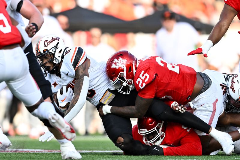 Nov 18, 2023; Houston, Texas, USA; Houston Cougars linebacker Jamal Morris (25) tackles Oklahoma State Cowboys running back Ollie Gordon II (0) during the second quarter at TDECU Stadium. Mandatory Credit: Maria Lysaker-USA TODAY Sports