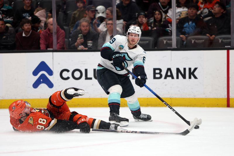 Dec 22, 2025; Anaheim, California, USA;  Seattle Kraken center Ben Meyers (59) passes the puck as Anaheim Ducks defenseman Pavel Mintyukov (98) defends him during the first period at Honda Center. Mandatory Credit: Kiyoshi Mio-Imagn Images