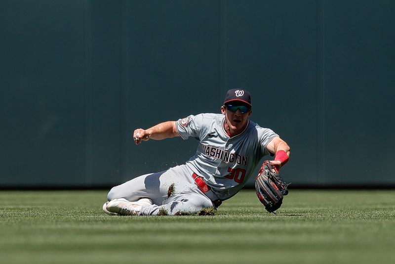 Jun 23, 2024; Denver, Colorado, USA; Washington Nationals center fielder Jacob Young (30) makes a diving catch in the sixth inning against the Colorado Rockies at Coors Field. Mandatory Credit: Isaiah J. Downing-USA TODAY Sports