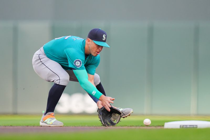 May 6, 2024; Minneapolis, Minnesota, USA; Seattle Mariners shortstop Dylan Moore (25) fields a ground ball against the Minnesota Twins in the second inning at Target Field. Mandatory Credit: Brad Rempel-USA TODAY Sports