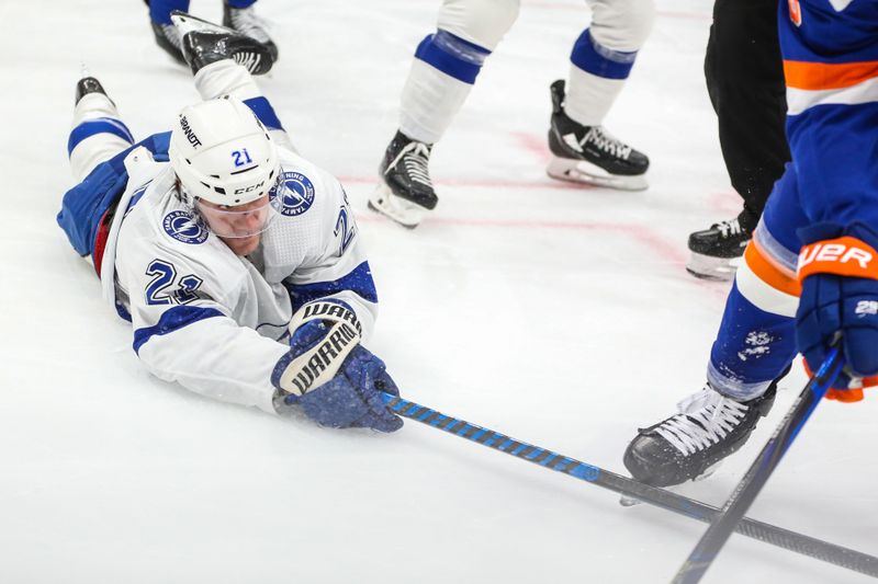 Feb 24, 2024; Elmont, New York, USA;  Tampa Bay Lightning center Brayden Point (21) reaches for the puck in the first period against the New York Islanders at UBS Arena. Mandatory Credit: Wendell Cruz-USA TODAY Sports