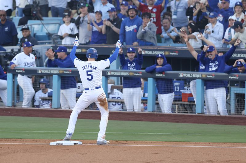 Oct 25, 2024; Los Angeles, California, USA; Los Angeles Dodgers first baseman Freddie Freeman (5) celebrates after hiting a triple in the first inning against the Los Angeles Dodgers  during game one of the 2024 MLB World Series at Dodger Stadium. Mandatory Credit:  Jason Parkhurst-Imagn Images