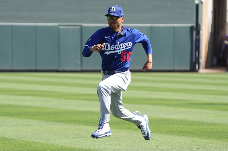 Feb 27, 2025; Salt River Pima-Maricopa, Arizona, USA; Los Angeles Dodgers shortstop Mookie Betts (50) warms up before a spring training game against the Colorado Rockies at Salt River Fields at Talking Stick. Mandatory Credit: Rick Scuteri-Imagn Images