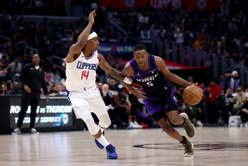 LOS ANGELES, CALIFORNIA - FEBRUARY 25: De'Aaron Fox #5 of the Sacramento Kings drives past Terance Mann #14 of the Los Angeles Clippers during the fourth quarter  at Crypto.com Arena on February 25, 2024 in Los Angeles, California. The Sacramento Kings defeated the Los Angeles Clippers 123-107. NOTE TO USER: User expressly acknowledges and agrees that, by downloading and or using this photograph, User is consenting to the terms and conditions of the Getty Images License Agreement. (Photo by Katelyn Mulcahy/Getty Images)