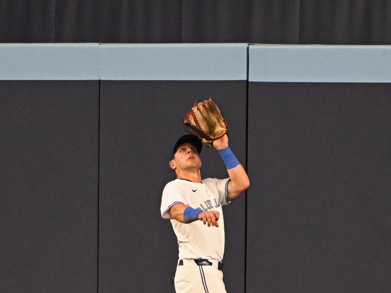 Aug 11, 2024; Toronto, Ontario, CAN; Toronto Blue Jays centre field Daulton Varsho (25) fields a fly ball in the ninth inning against the Oakland Athletics at Rogers Centre. Mandatory Credit: Gerry Angus-USA TODAY Sports