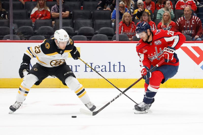 Oct 5, 2024; Washington, District of Columbia, USA; Washington Capitals center Nic Dowd (26) and Boston Bruins right wing Fabian Lysell (23) battle for the puck in the first period at Capital One Arena. Mandatory Credit: Geoff Burke-Imagn Images