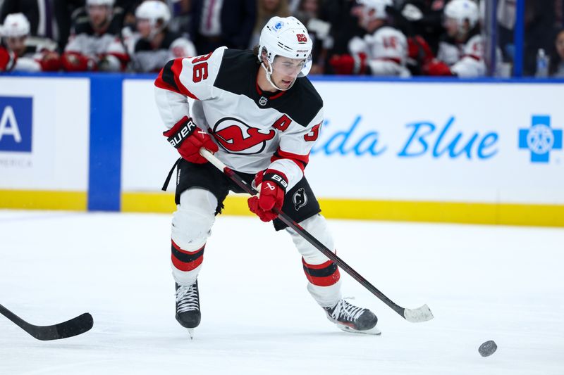 Nov 16, 2024; Tampa, Florida, USA; New Jersey Devils center Jack Hughes (86) controls the puck against the Tampa Bay Lightning in the second period at Amalie Arena. Mandatory Credit: Nathan Ray Seebeck-Imagn Images