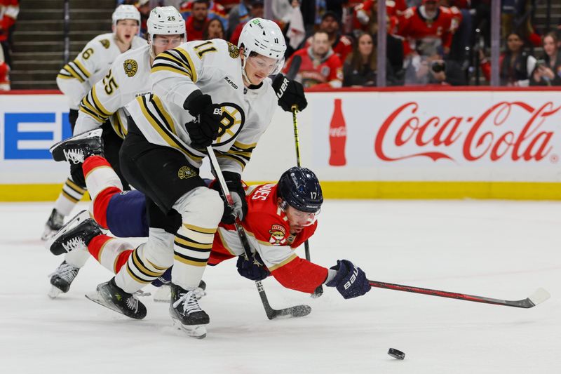 May 8, 2024; Sunrise, Florida, USA; Florida Panthers center Evan Rodrigues (17) dives for the puck against Boston Bruins center Trent Frederic (11) and defenseman Brandon Carlo (25) during the first period in game two of the second round of the 2024 Stanley Cup Playoffs at Amerant Bank Arena. Mandatory Credit: Sam Navarro-USA TODAY Sports